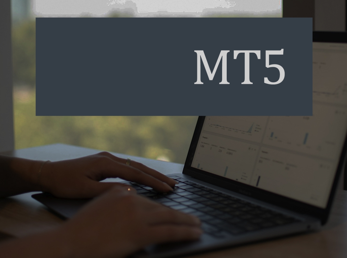 Forex trader analyzing customizable MT5 dashboard on laptop.